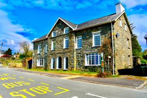 an old stone house on the side of a street at Spacious Garden Flat in Snowdonia National Park in Brynkir