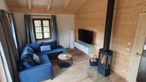 sala de estar con sofá azul y chimenea en Ökologisches Holzblock-Ferienhaus 150 im Lauterdörfle zu vermieten - Neubau, en Hayingen