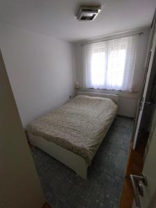 a small bedroom with a bed and a window at Apartment Roki in Zagreb