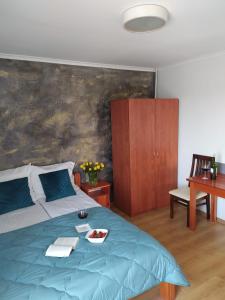 a bedroom with a blue bed with a plate of food on it at Bosman Pokoje Gościnne in Mielenko