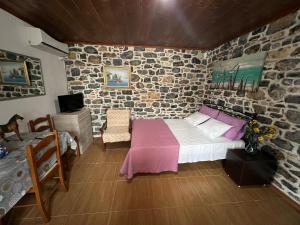 Mountain House في Gáïa: غرفة نوم بسرير وجدار حجري