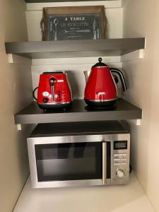 a microwave with two tea pots on top of it at Paris Lorne in Lorne