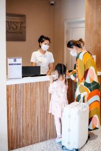 una donna e una bambina in piedi accanto a un bancone di VST Punnawithi a Bangkok