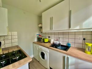 a kitchen with a sink and a washing machine at Underneath the Arches in Penicuik