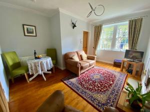 a living room with a chair and a table at Underneath the Arches in Penicuik