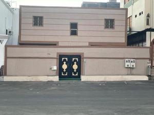 a building with a green door in front of it at شقق شاطئ النخيل in Umm Lajj