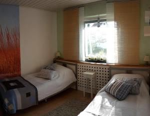 duas camas num quarto com uma janela e uma janela em Städtle-Blick em Hayingen