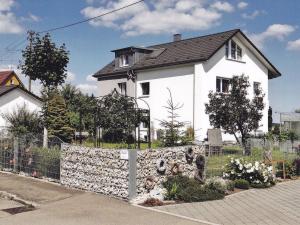 ein weißes Haus mit einem Zaun davor in der Unterkunft Städtle-Blick in Hayingen