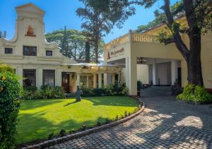 una gran casa blanca con un árbol en el patio en Amritara The Poovath Beachfront Heritage, Fort Kochi, en Kochi