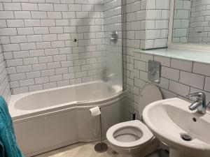 een badkamer met een wit bad, een toilet en een wastafel bij Entire Studio in picturesque City Islands - Short Walk from Leeds Centre in Leeds