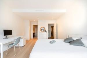 a white bedroom with a desk and a bed at Lux City Hamilius - Modern & Spacious Apart w/View in Luxembourg