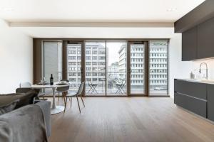 een keuken en een woonkamer met een tafel en stoelen bij Lux City Hamilius - Modern & Spacious Apart w/View in Luxemburg