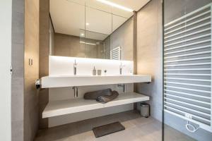 W łazience znajduje się umywalka i lustro. w obiekcie Lux City Hamilius - Modern & Spacious Apart w/View w Luksemburgu