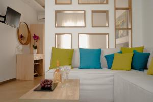 a living room with a white couch with blue and green pillows at Polis of Naxos Boutique Hotel in Naxos Chora
