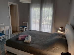 a bedroom with a large bed with two towels on it at 2SEA VILLA Nea Potidea CHALKIDIKI in Nea Potidaea