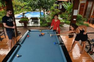 a group of people standing around a pool table at Tam Coc Melody Homestay in Ninh Binh