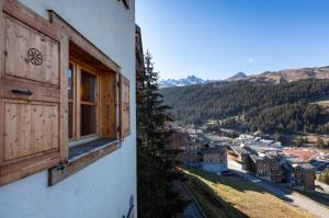 a building with a window and a view of a town at TERRESENS - LES CASCADES in Courchevel