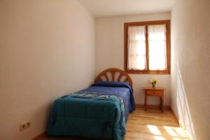 ベナスケにあるApartamentos Los Tilosの小さなベッドルーム(ベッド1台、窓付)