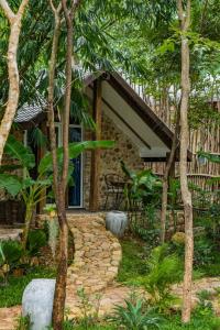 a house in the middle of a garden with trees at Green Valley Veal Pouch in Kampot