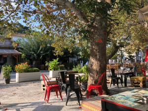 un grupo de mesas y sillas bajo un árbol en Poraika studios, en Raches