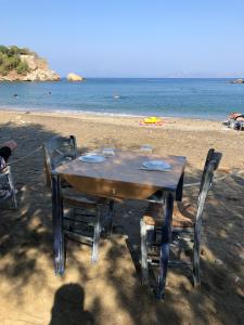 a table and chairs sitting on the beach at Poraika studios in Raches