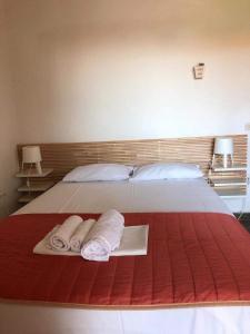 a bed with two towels and two pillows on it at Sarizas Apartments in Siviri
