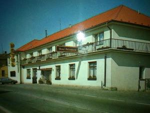 un gran edificio blanco con balcón en una calle en Hotel Bělohlávek, en Holoubkov