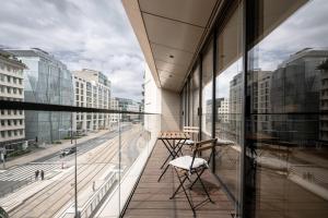a chair on a balcony with a view of a street at Lux City Hamilius - Modern & Spacious Apart w/View in Luxembourg