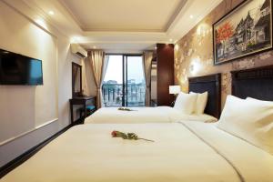 Golden Legend Boutique Hotel في هانوي: غرفه فندقيه سريرين وتلفزيون