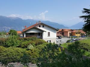 a white house on a hill with a parking lot at Holiday Home near Lago Maggiore Pool in Porto Valtravaglia