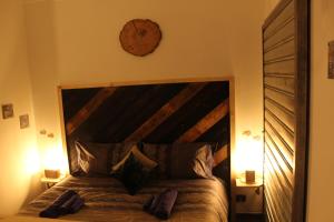 - une chambre avec un grand lit et une horloge murale dans l'établissement L'ango-letto industriale del Quadrilatero Romano, à Turin