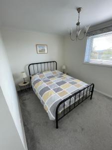 1 dormitorio con 1 cama con manta a cuadros en Dumbarton With A View, en Dumbarton