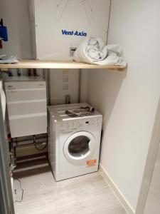 a laundry room with a washing machine on a shelf at 23 floor studio for work 1Gb WiFi in Croydon