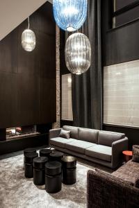 a living room with a couch and stools and lights at Hôtel Louvre-Lens - Esprit de France in Lens