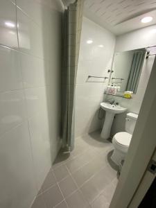 a white bathroom with a toilet and a sink at Seoul Grand Hostel Edae in Seoul +56 photos