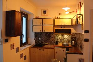 Elle comprend une petite cuisine avec des placards en bois et une fenêtre. dans l'établissement L'ango-letto industriale del Quadrilatero Romano, à Turin