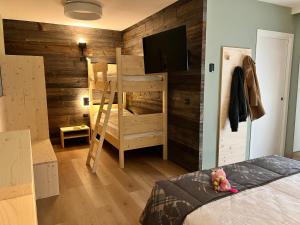 a bedroom with a wooden wall with a bunk bed at Family Hotel La Perla in Fiera di Primiero
