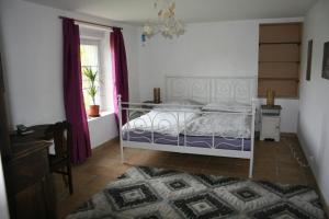 a bedroom with a white bed and a window at Kercapitaine in Bannalec