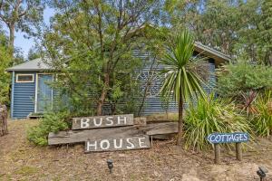 a house with a bush house sign in front of it at Lorne Bush House Cottages & Eco Retreats in Lorne