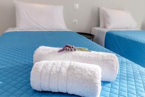 a blue bed with two towels on top of it at Elena-Stella Apartments Arillas Corfu in Arillas