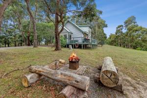 a fire pit in front of a house at Lorne Bush House Cottages & Eco Retreats in Lorne