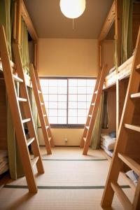 ゲストハウス君彩家 kimidoriya في أوساكا: غرفة مع سرير بطابقين ونوافذ كبيرة