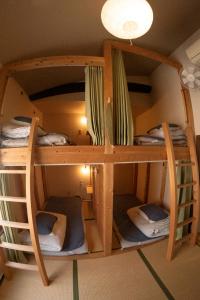 a room with three bunk beds in a room at ゲストハウス君彩家 kimidoriya in Osaka