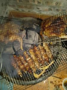 a bunch of food cooking on a grill at A Kiệt Homestay in Mèo Vạc