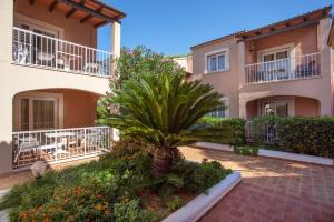 a palm tree in front of a building at Agulla park in Cala Ratjada