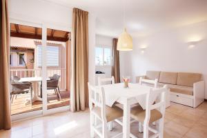 een woonkamer met een witte tafel en stoelen bij Agulla park in Cala Ratjada