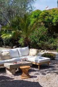 a white couch and a coffee table in a yard at Lou Cagnard in Saint-Tropez