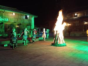 a group of people standing around a large fire at A Kiệt Homestay in Mèo Vạc