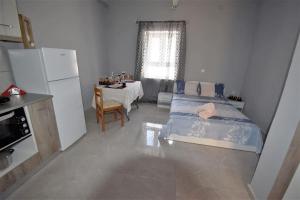 una camera con letto e una cucina con tavolo di MOSHOVIA STUDIO Κάρπαθος στο κέντρο και ήσυχα a Karpathos