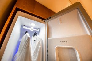 a bathroom with a glass door with white robes at Hotel the Hill in Gwangju